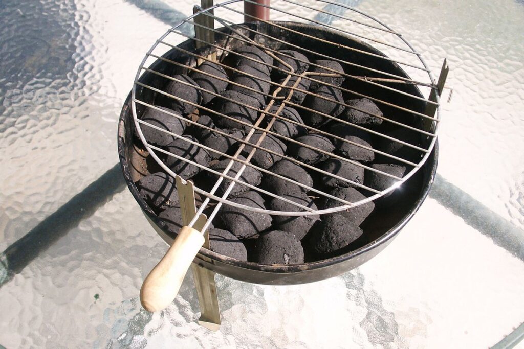 Charcoal brazier grill loaded with fresh lump charcoal